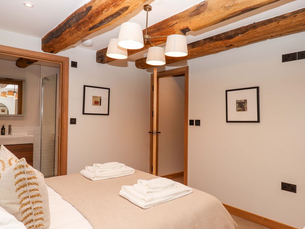 A bedroom with a bed and towels at Lower Walreddon Barn in Tavistock