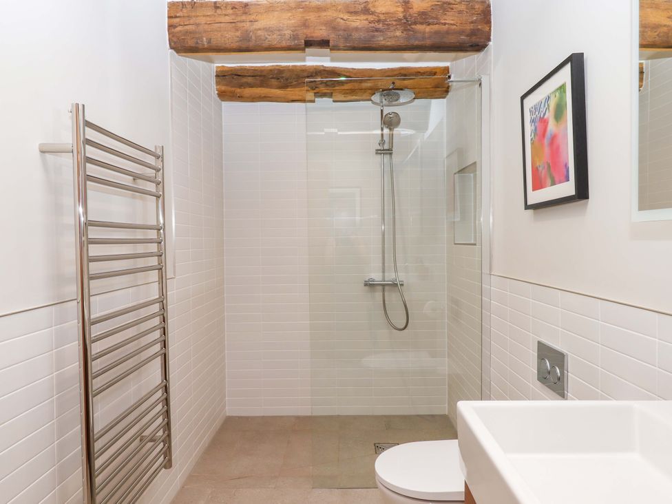 A bathroom with a shower and towel rail at Lower Walreddon Barn in Tavistock
