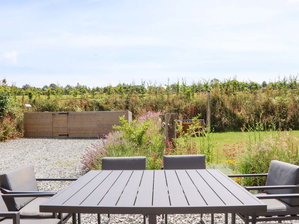 A garden with a table and chairs at Lower Walreddon Barn in Tavistock