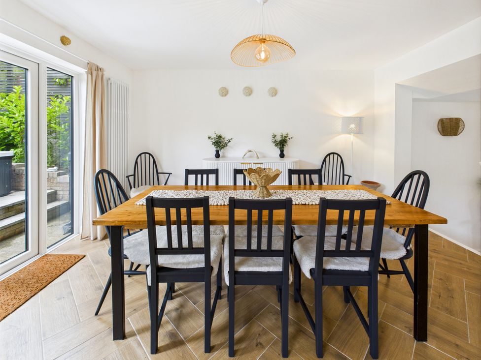 A dining room with a wooden table and chairs at 59a Gwscwm Road