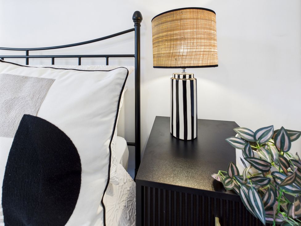 A bedroom with a bed and lamp on a nightstand at 59a Gwscwm Road 