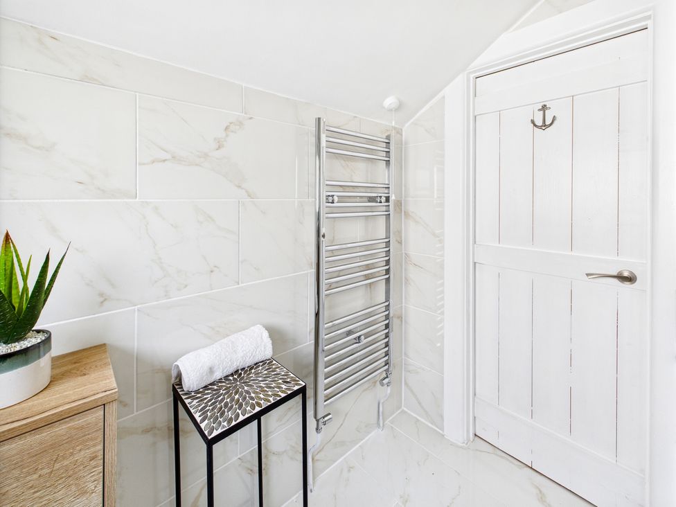 A bathroom with a towel rack and a plant at 59a Gwscwm Road 