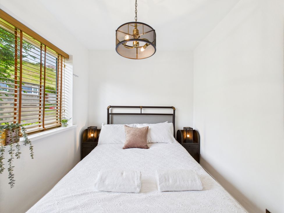 A bedroom with a bed and window at 59a Gwscwm Road