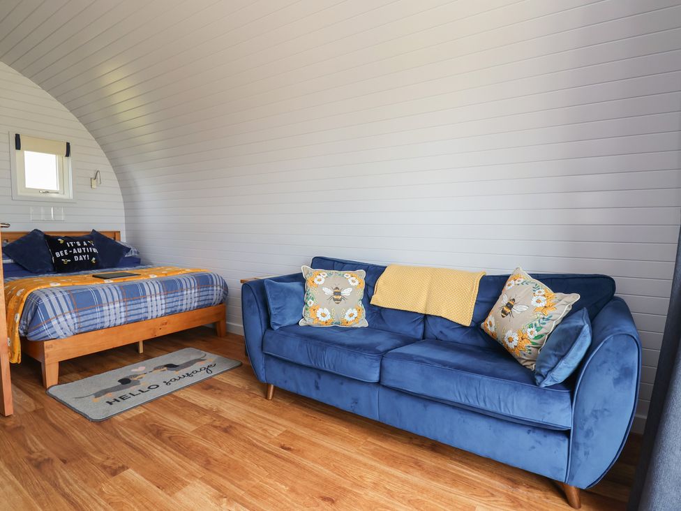 A bedroom with a bed and sofa at Honeypot Hideaways - Manuka