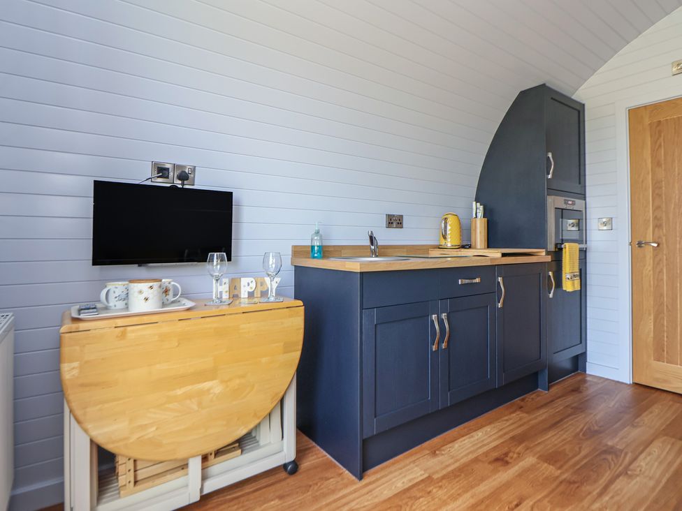 A kitchen with a sink and television at Honeypot Hideaways - Manuka