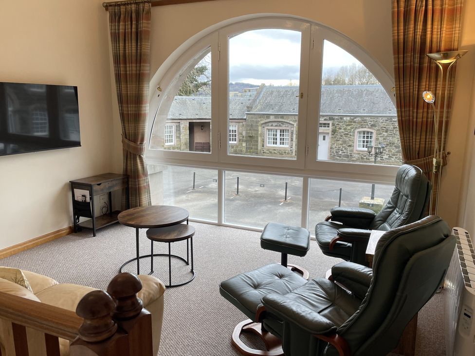 A living room with a television and seating area at The ClockTower in Perth