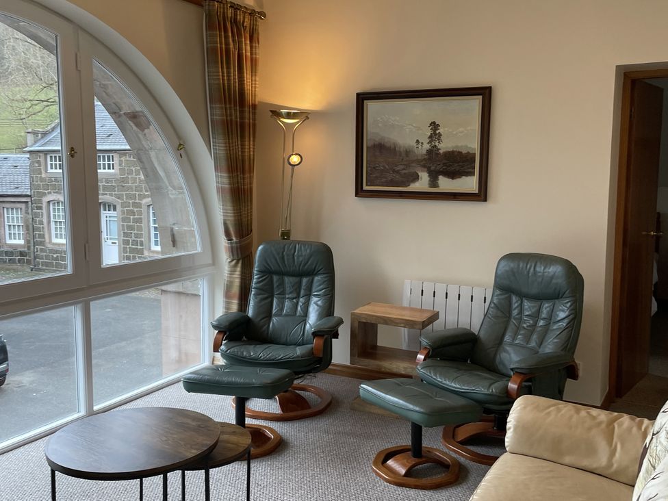 A living room with green armchairs and a small table at The ClockTower in Perth