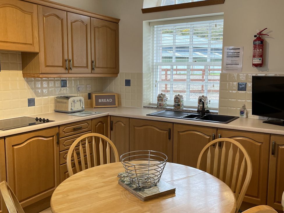A kitchen with wooden cabinets and a dining table at The ClockTower in Perth
