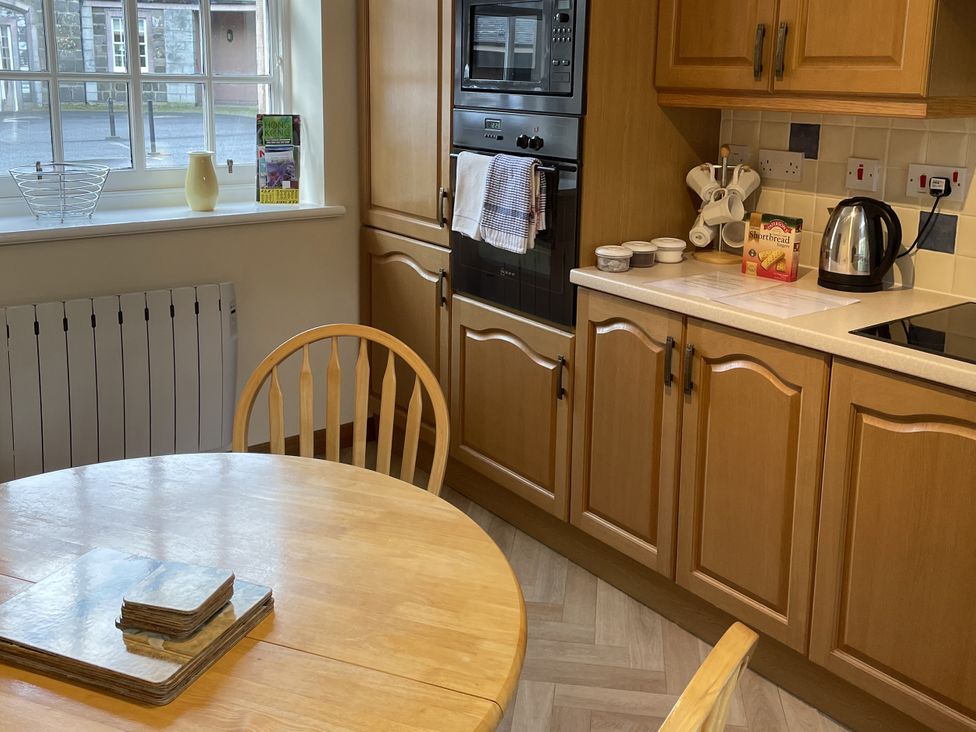 A kitchen with a table and chair at The ClockTower in Perth