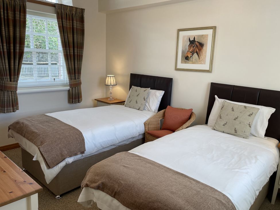A bedroom with two single beds and a nightstand at The ClockTower in Perth