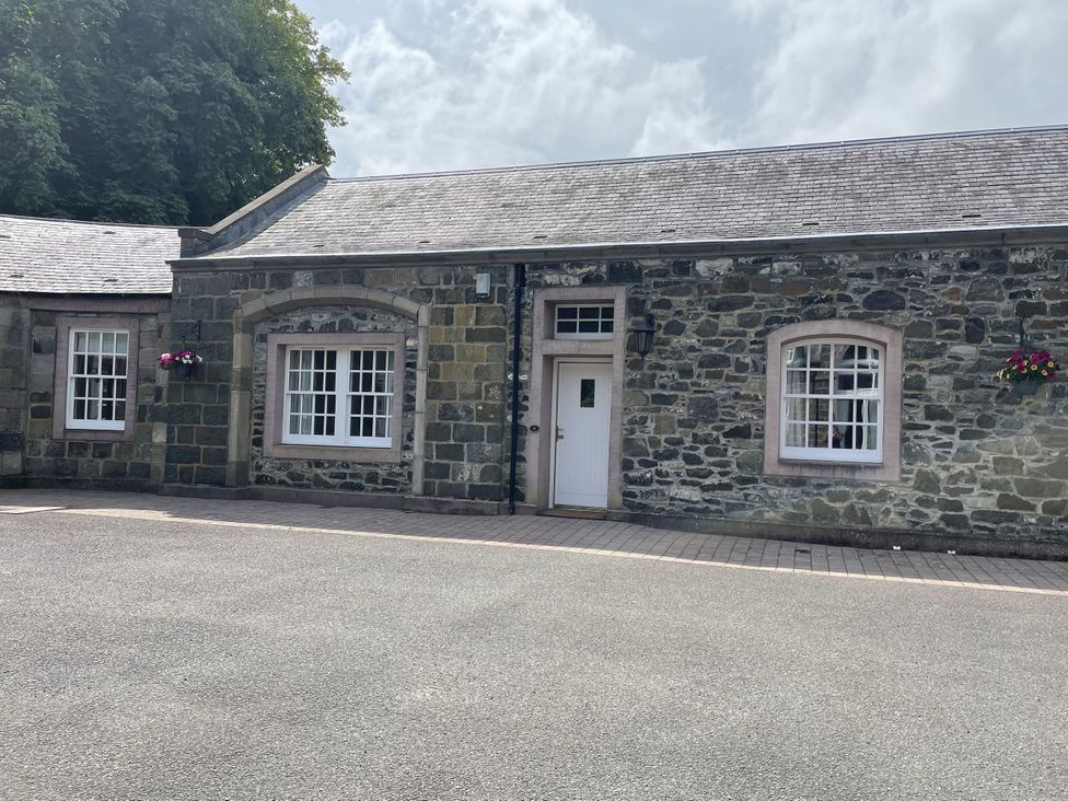 An exterior view of a stone building with windows and door at Coach House 4 Perth