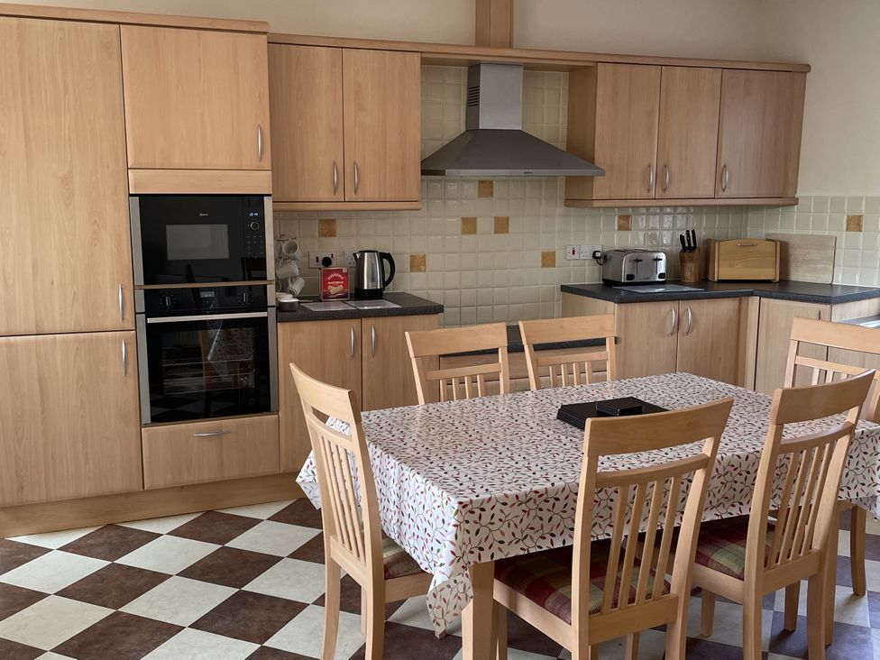 A kitchen with a dining table and chairs at Coach House 4 in Perth