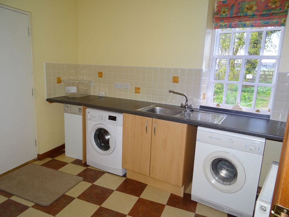 A laundry room with washing machine and sink at Coach House 4 in Perth