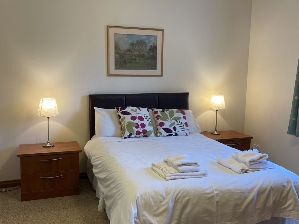 A bedroom with a bed and bedside tables at Coach House 4 in Perth