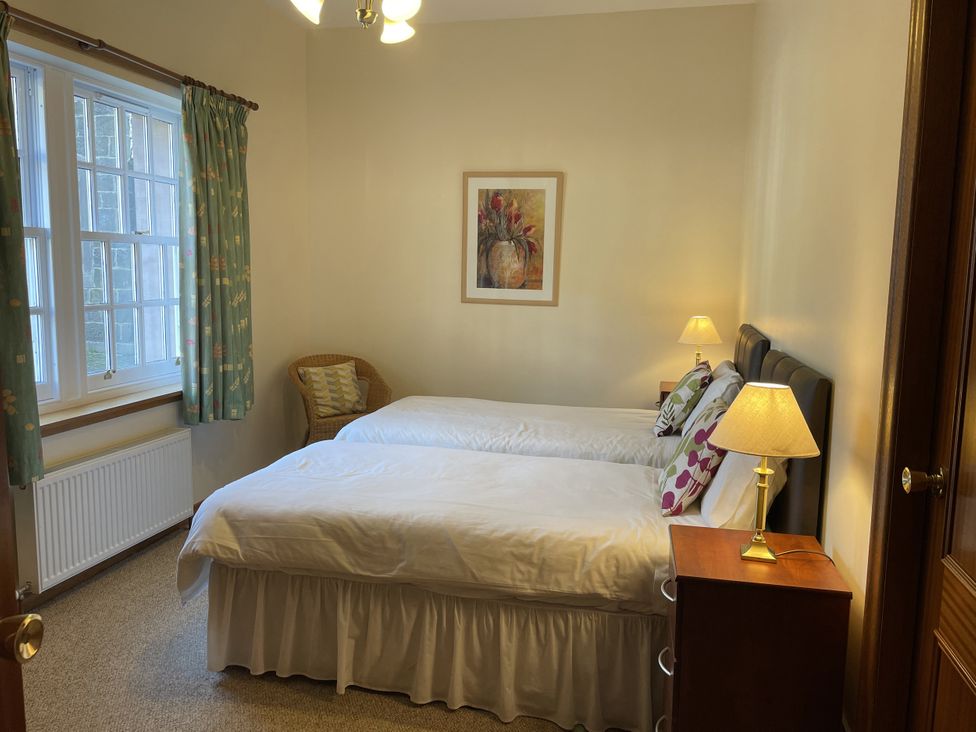 A bedroom with two beds and a lamp at Coach House 4 in Perth