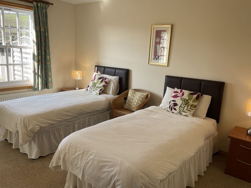 A bedroom with two beds and a nightstand at Coach House 4 in Perth