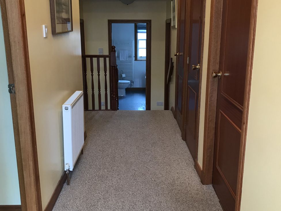 A hallway with a radiator and doors at Coach House 5 in Perth