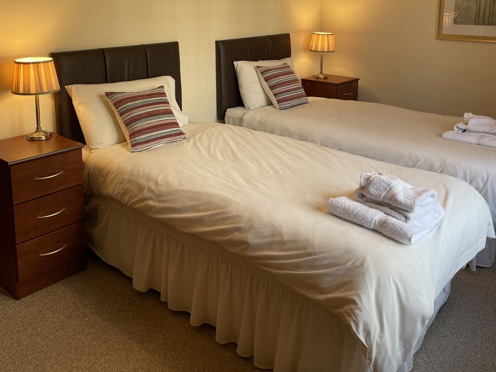 A bedroom with two beds and a nightstand at Coach House 5 Perth