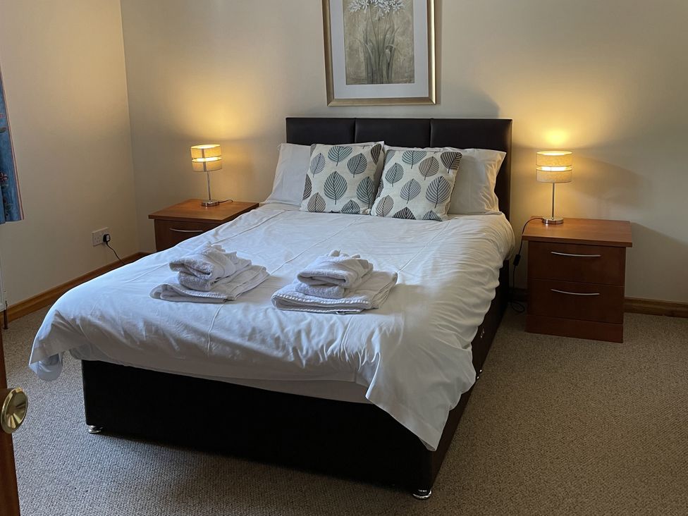 A bedroom with a bed and nightstands at Coach House 5 in Perth