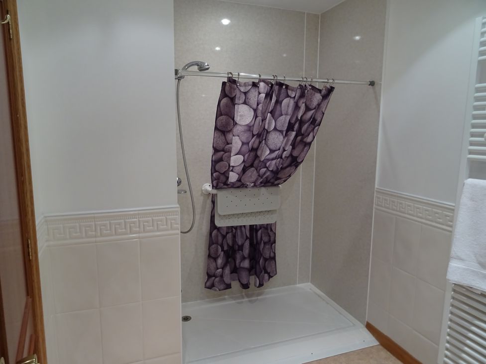 A bathroom with a shower and a patterned curtain at Coach House 5 in Perth