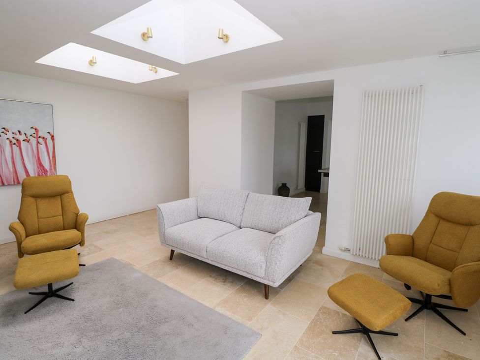 A living room with a sofa and armchairs at The Cottage in Ballinagleira