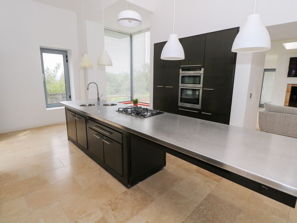 A kitchen with an island and modern appliances at The Cottage in Ballinagleira
