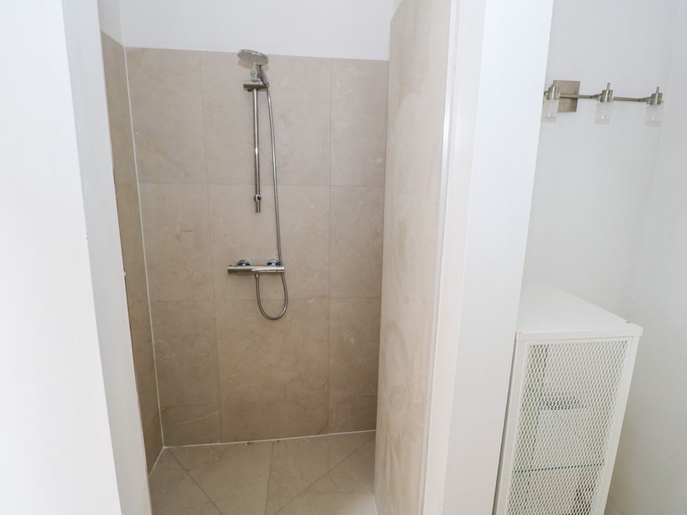 A shower with a storage cabinet at The Cottage in Ballinagleira