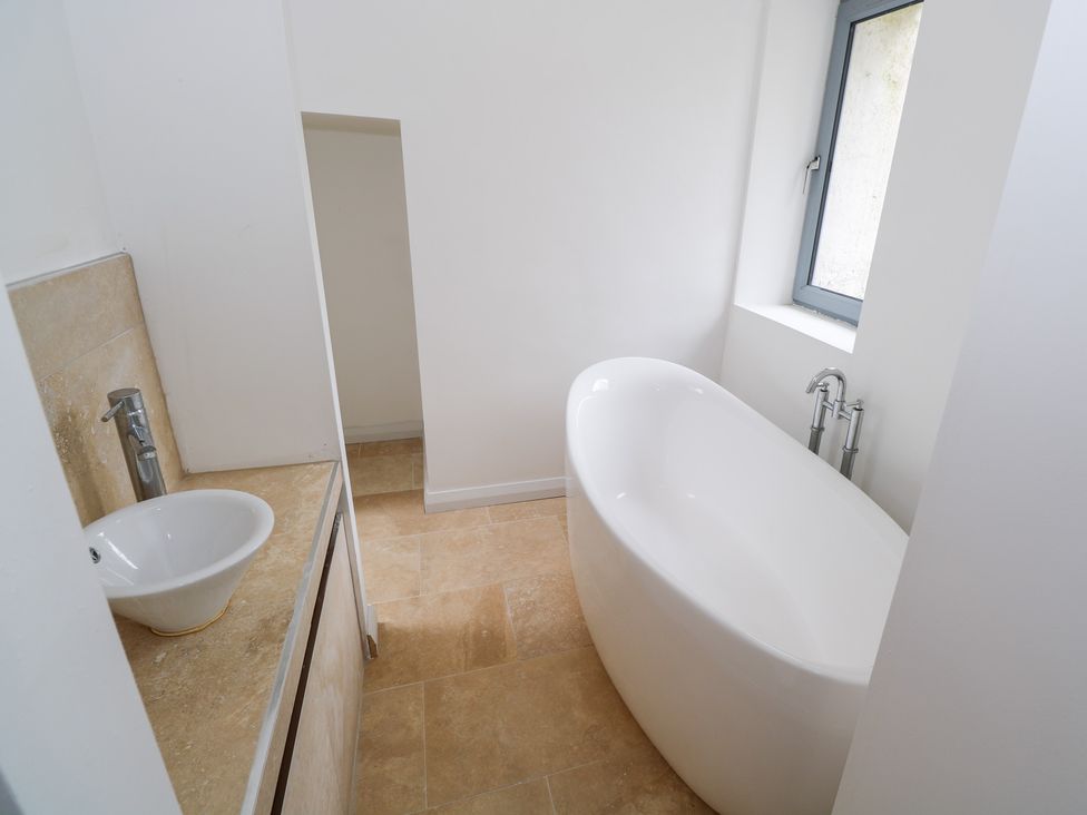 A bathroom with a bathtub and a sink at The Cottage in Ballinagleira