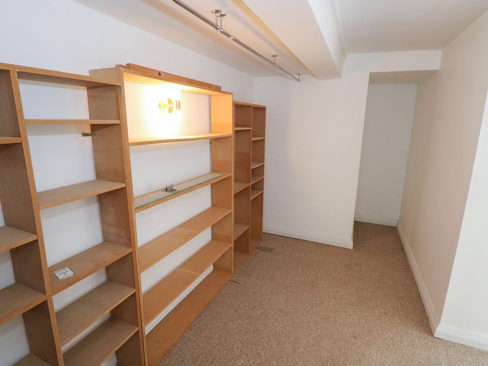 A storage room with wooden shelves and a light fixture at The Cottage in Ballinagleira