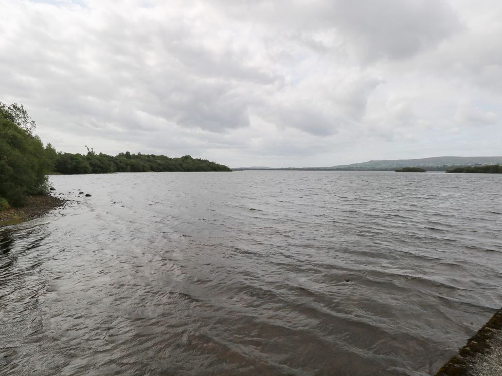 A lake view with trees along the shoreline at The Cottage in Ballinagleira