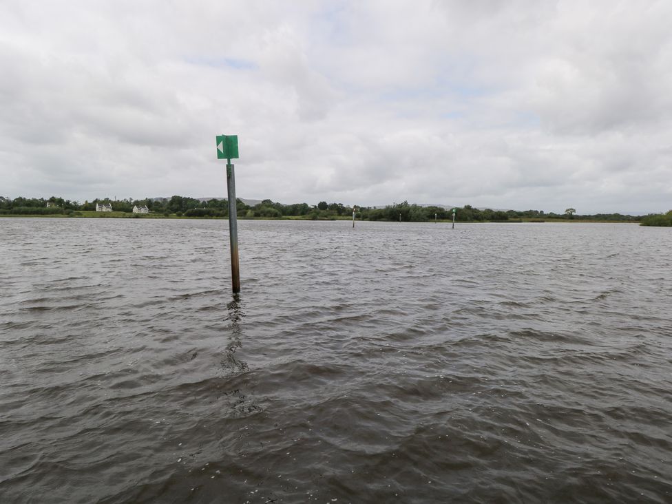 A view of water with navigation markers and houses at The Cottage in Ballinagleira