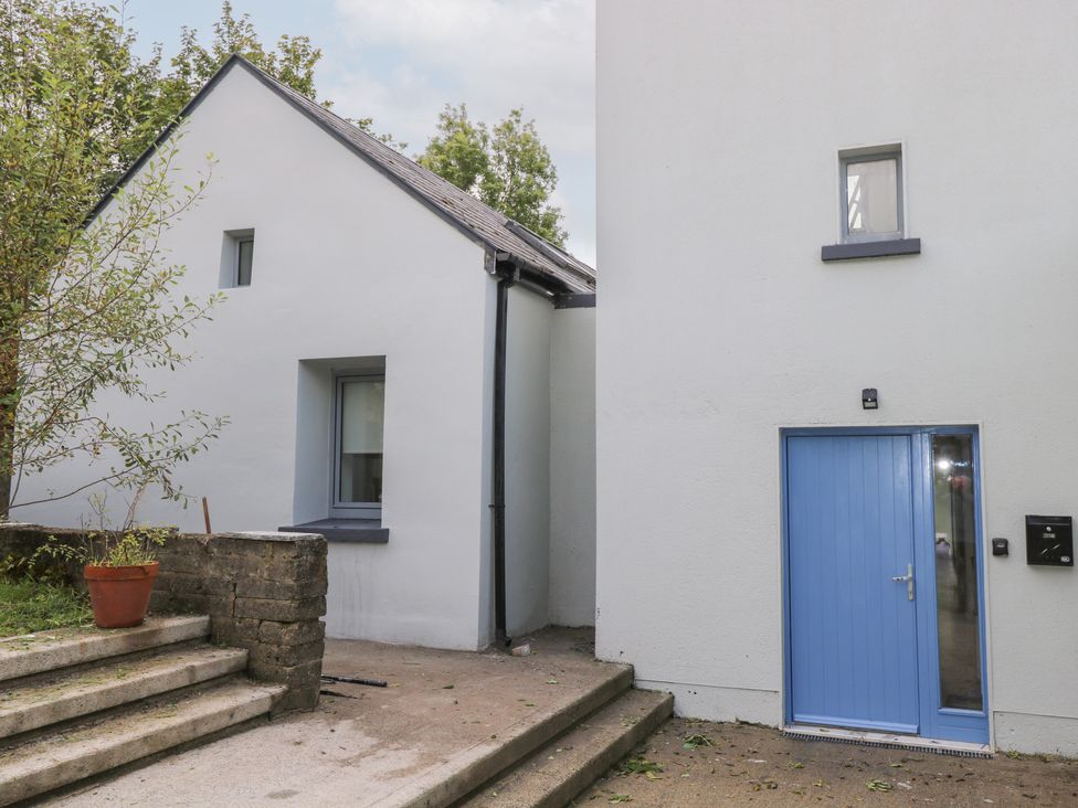 A house exterior with steps and a blue door at The Cottage in Ballinagleira