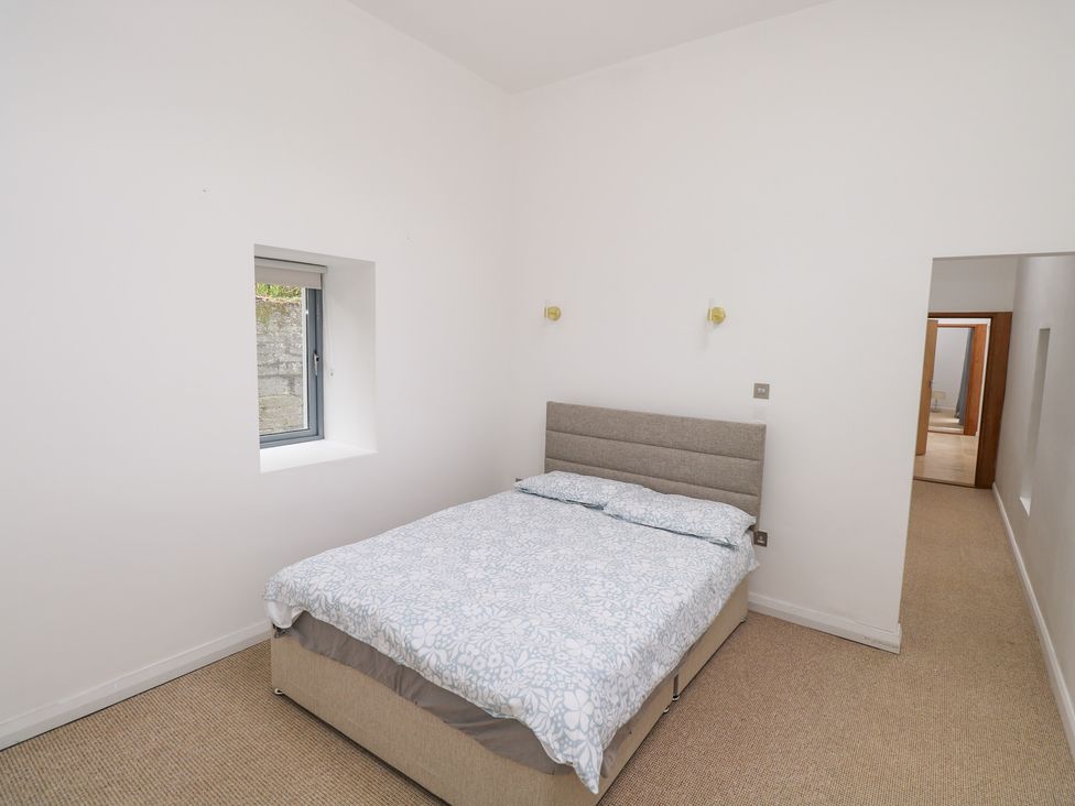 A bedroom with a bed and a window at The Cottage in Ballinagleira