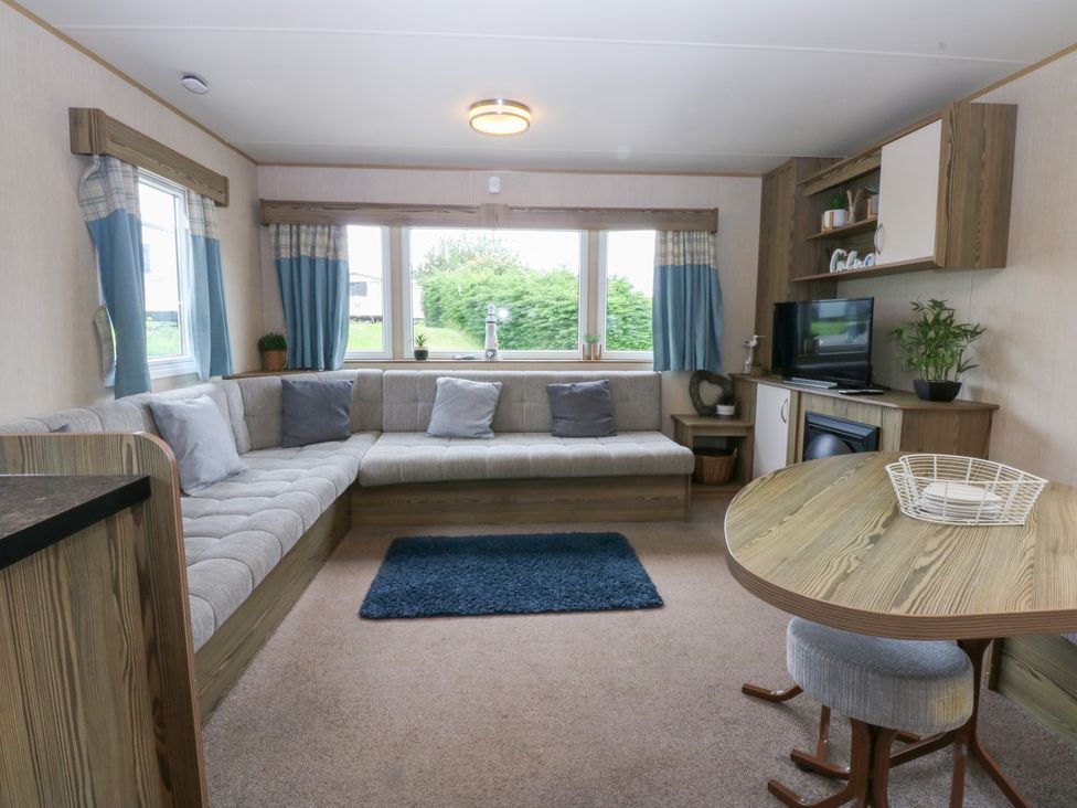 A living room with a sofa and TV at Mountain View in Pwllheli