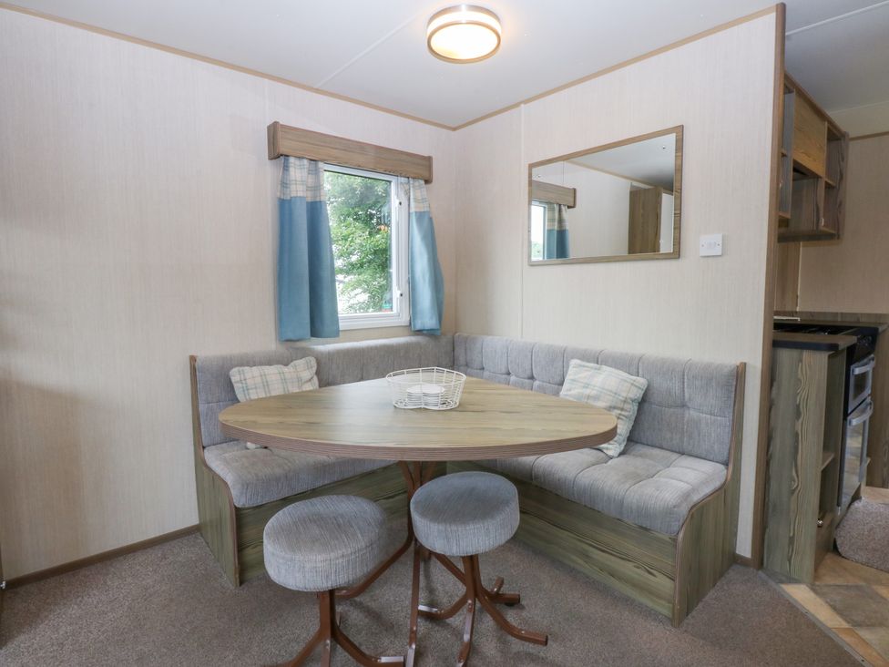 A dining area with a table and benches at Mountain View in Pwllheli