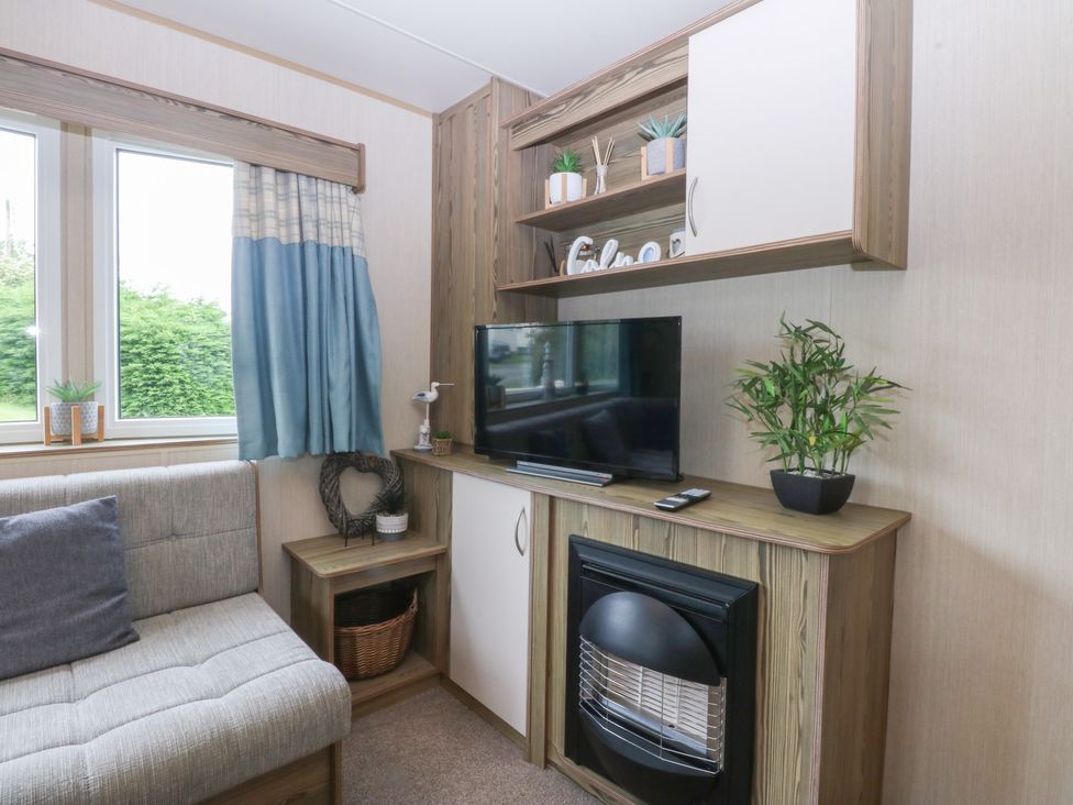 A living room with a television and a couch at Mountain View in Pwllheli
