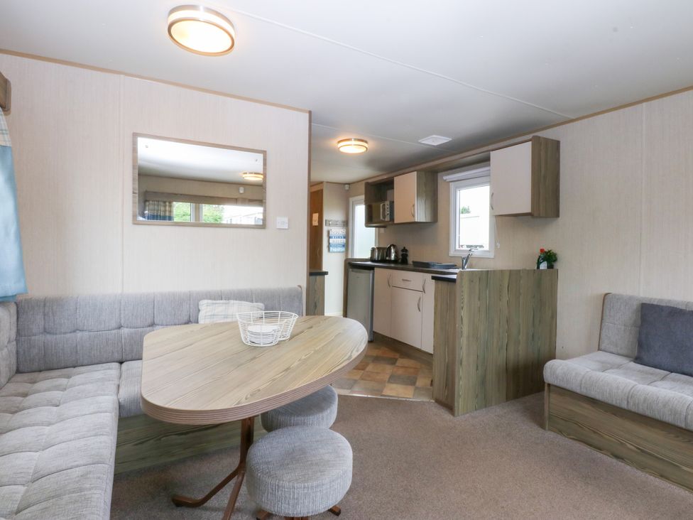 A living room with a table and sofa at Mountain View in Pwllheli