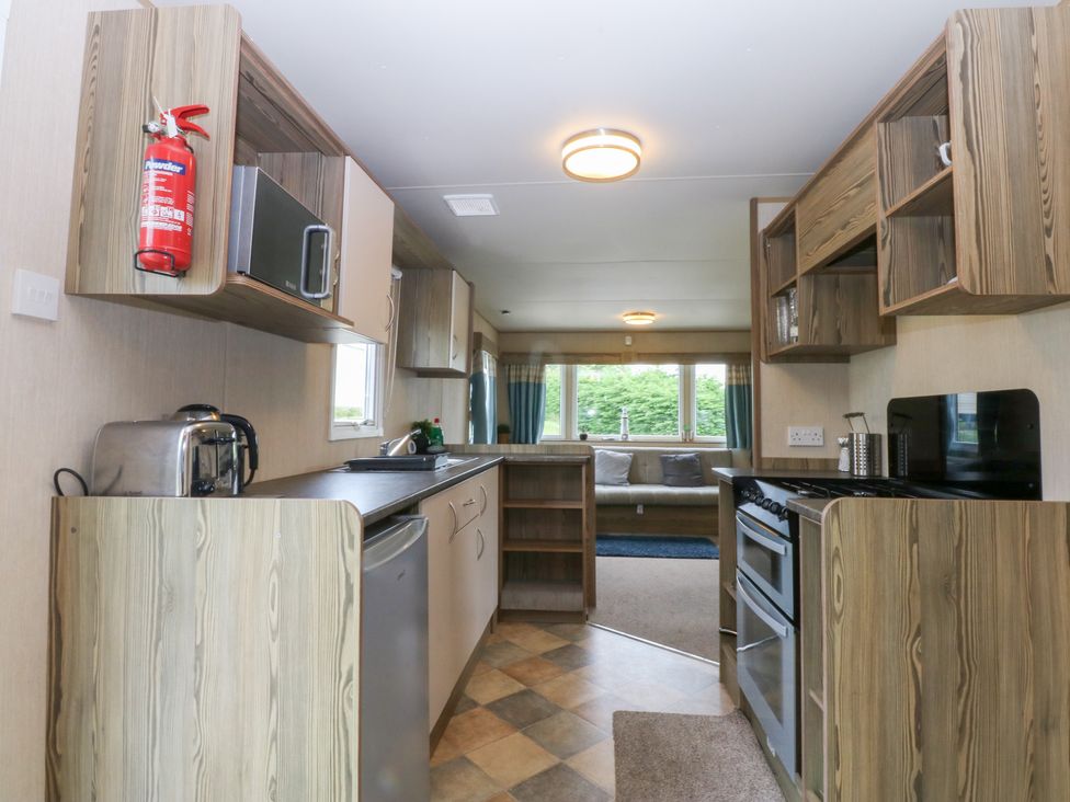 A kitchen with refrigerator and stove at Mountain View in Pwllheli