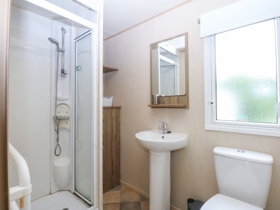 A bathroom with a shower, sink, and toilet at Mountain View in Pwllheli
