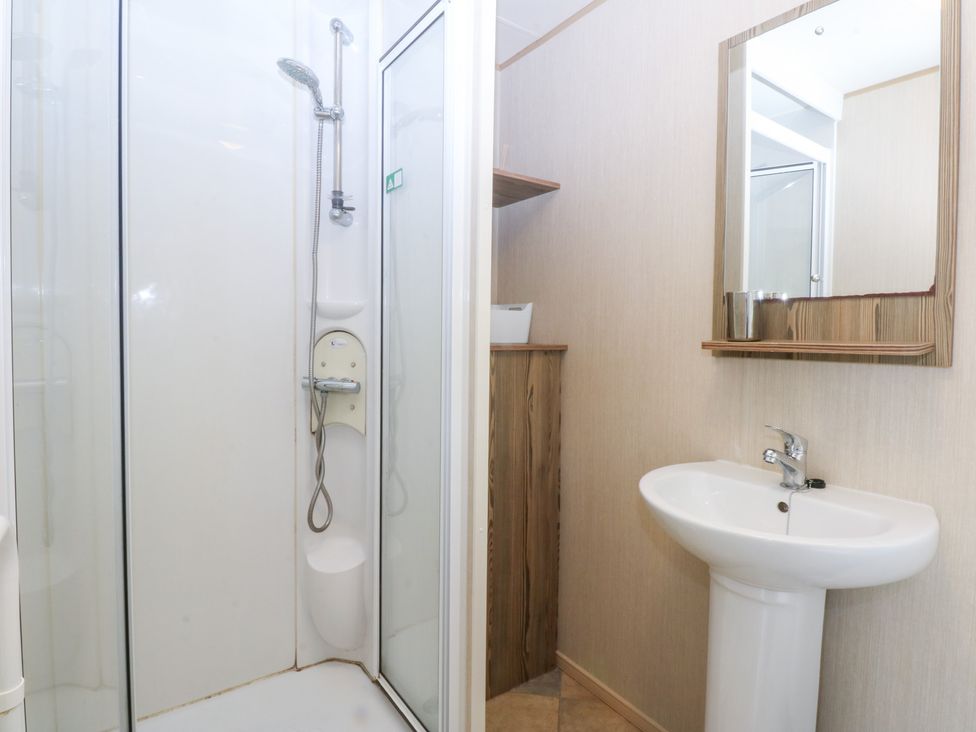 A shower and sink in a bathroom at Mountain View Pwllheli