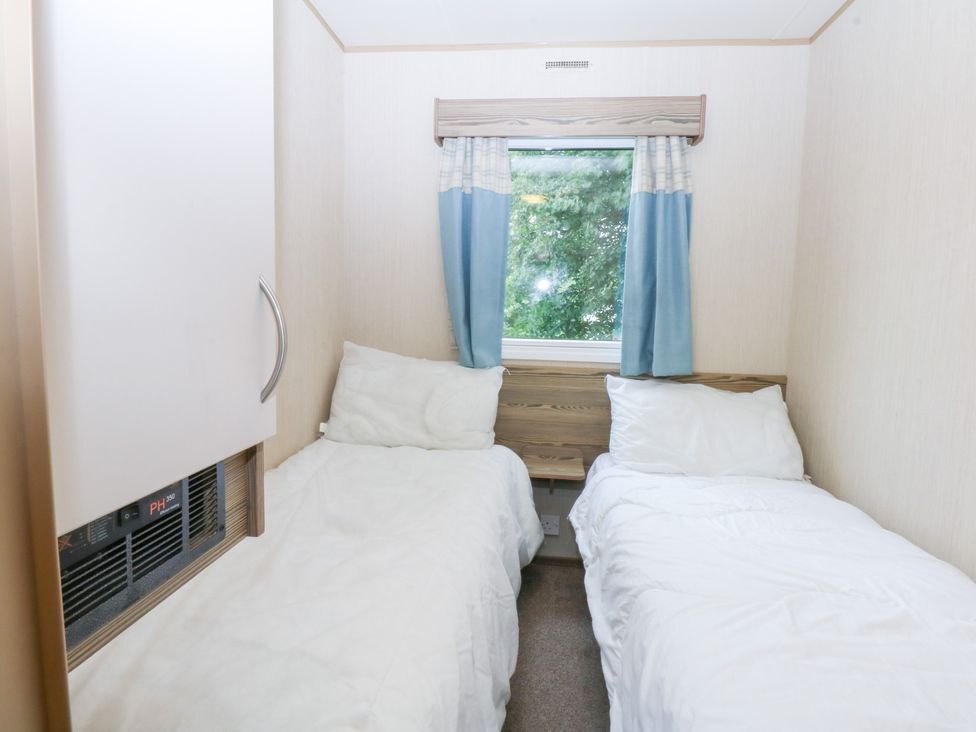 A bedroom with two beds and a window at Mountain View in Pwllheli