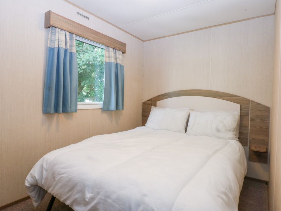 A bedroom with a bed and window at Mountain View in Pwllheli