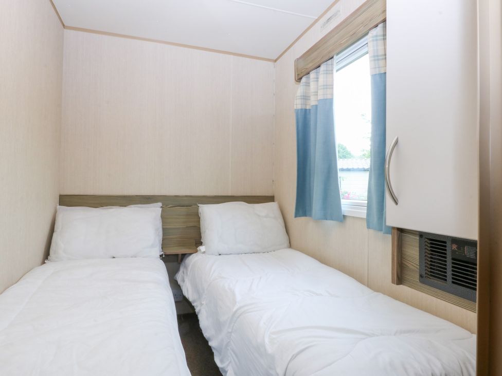A bedroom with two beds and a window at Mountain View in Pwllheli