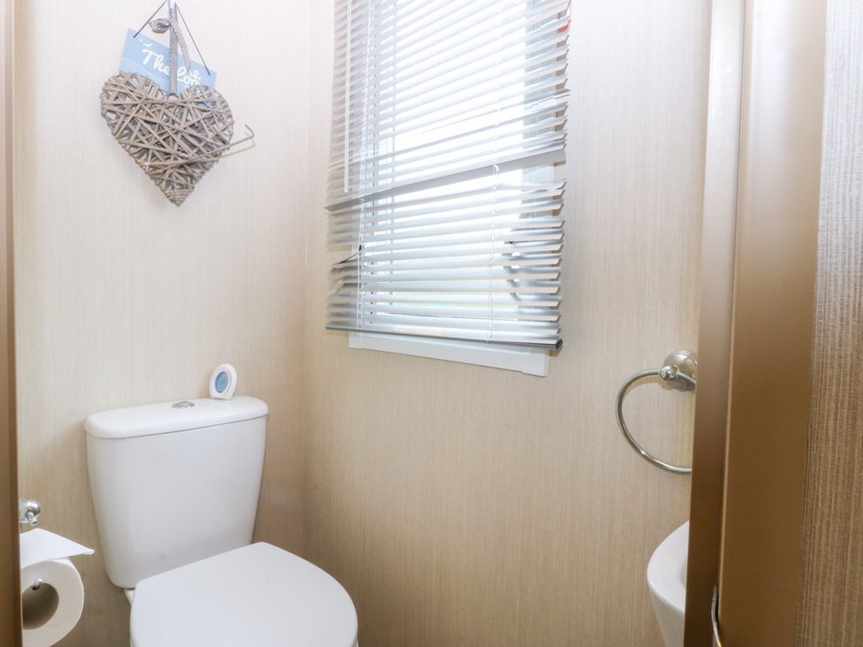 A bathroom with a toilet and window at Mountain View in Pwllheli