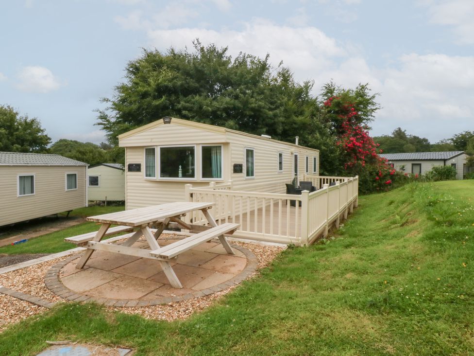 An outdoor area with a mobile home and picnic table at Mountain View in Pwllheli