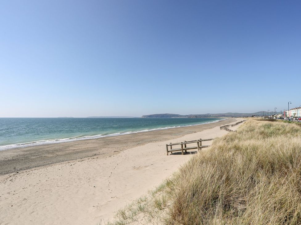 A beach with sand and sea at Mountain View Haven near Pwllheli