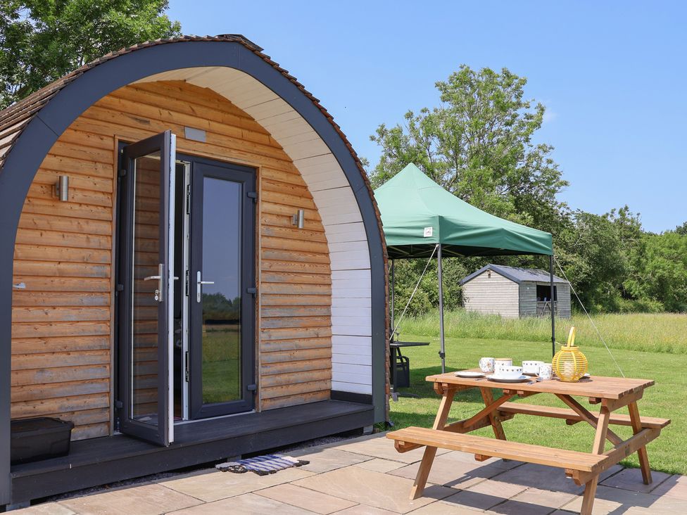 A cabin with outdoor seating and tent at Honeypot Hideaways - Clover