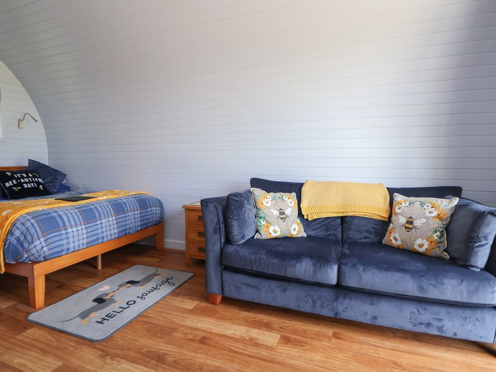 A bedroom with a bed and sofa at Honeypot Hideaways - Clover