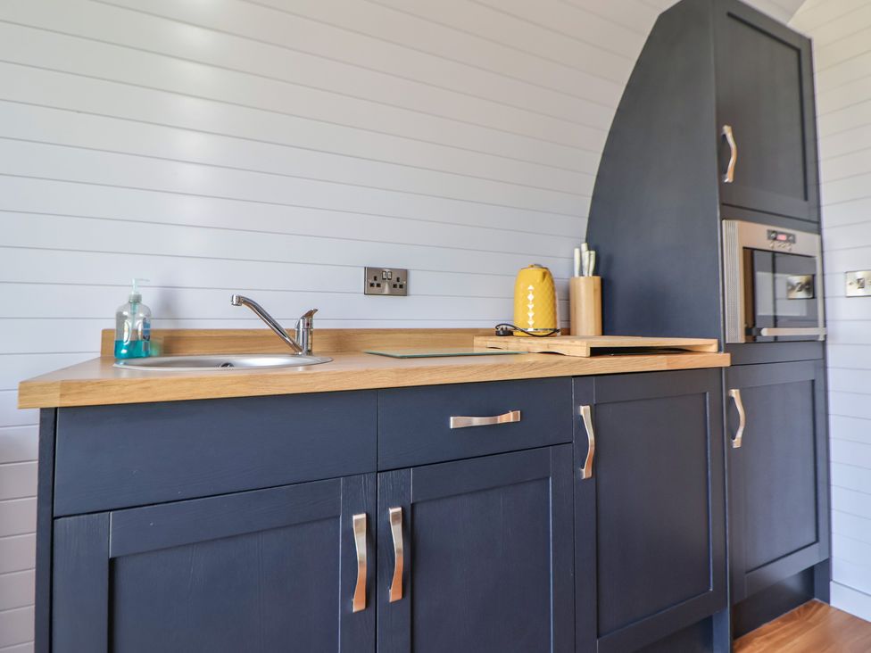 A kitchen with a sink and oven at Honeypot Hideaways - Clover
