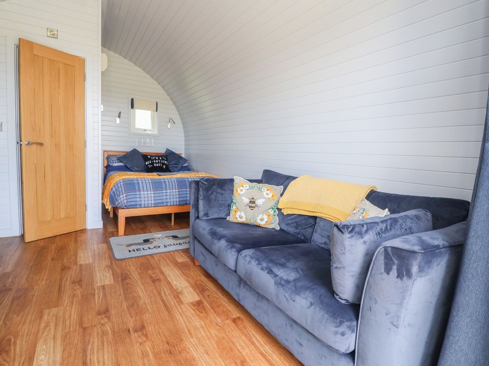A bedroom with a bed and sofa at Honeypot Hideaways - Clover